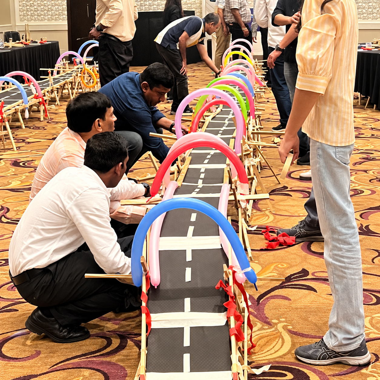 Participants assembling a long bridge structure